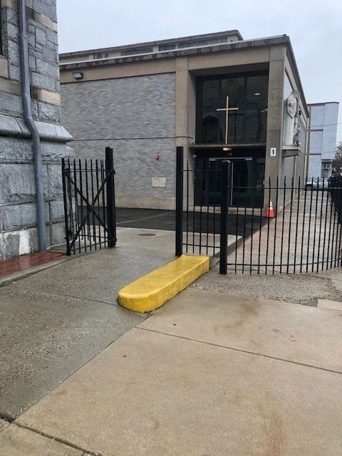 Church entrance with open iron gate and cross